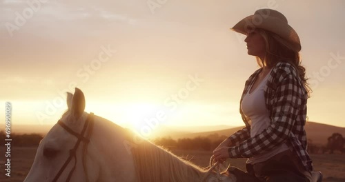 Sunset, woman or horse riding at sunset to relax with rider or jockey for adventure, peace or wellness. View, ranch or cowgirl with a healthy pet animal for journey, freedom or travel on farm field