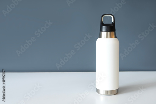 Reusable eco steel thermo water bottle on table. 