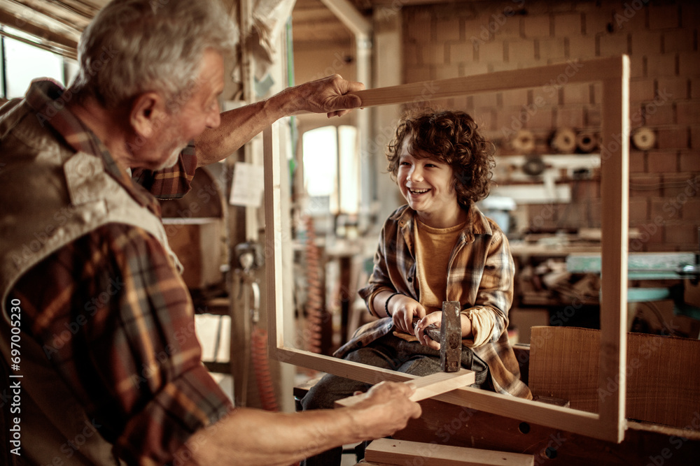 Little grandson having fun with grandfather in a carpentry shop Little grandson having fun with grandfather in a carpentry shop