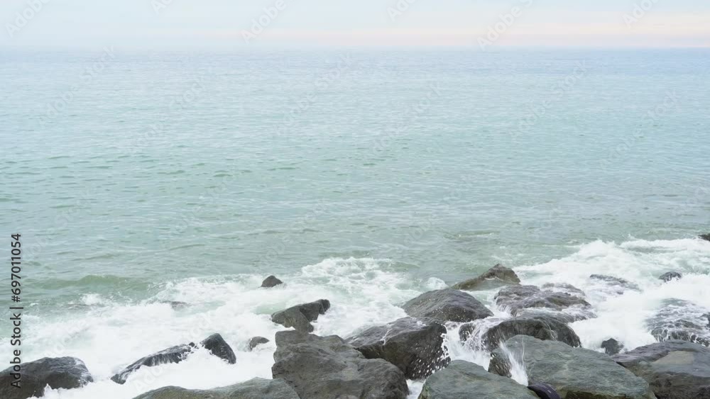 Sea waves hit the rocky shore creating splashes. Calmness and tranquility, meditation and relaxation, a screensaver of natural beauty. Rocky shore and waves Sea waves hit the rocky shore creating splashes. Calmness and tranquility, meditation and relaxation, a screensaver of natural beauty. Rocky shore and waves