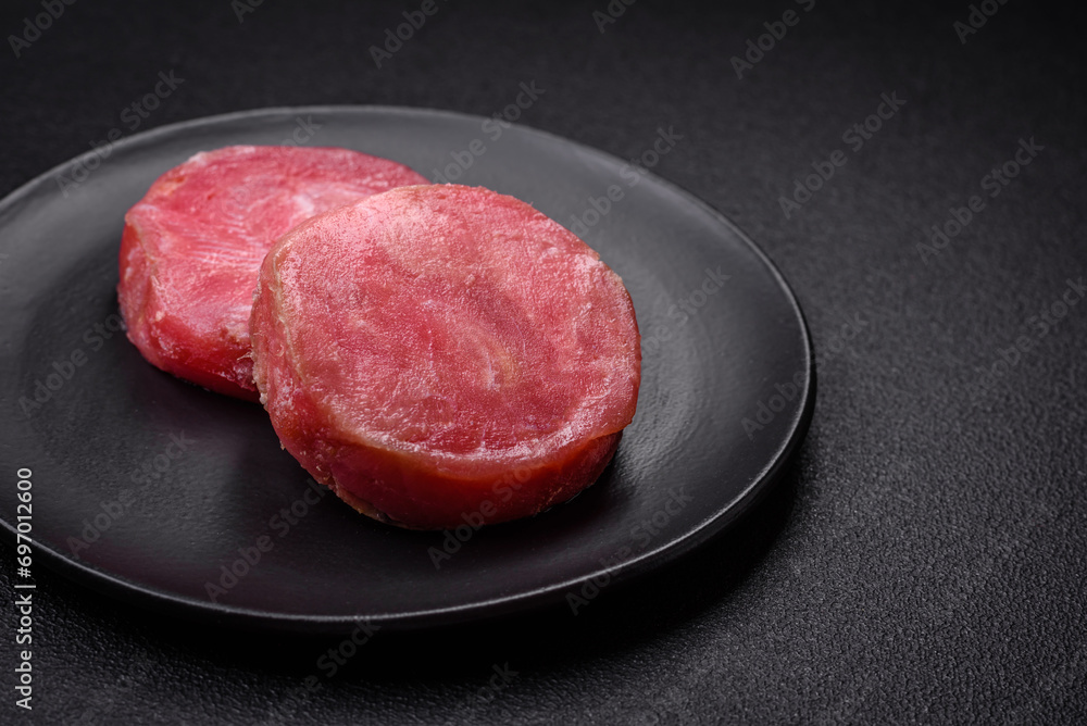 Round shape steaks of raw juicy tuna with salt and spices Round shape steaks of raw juicy tuna with salt and spices