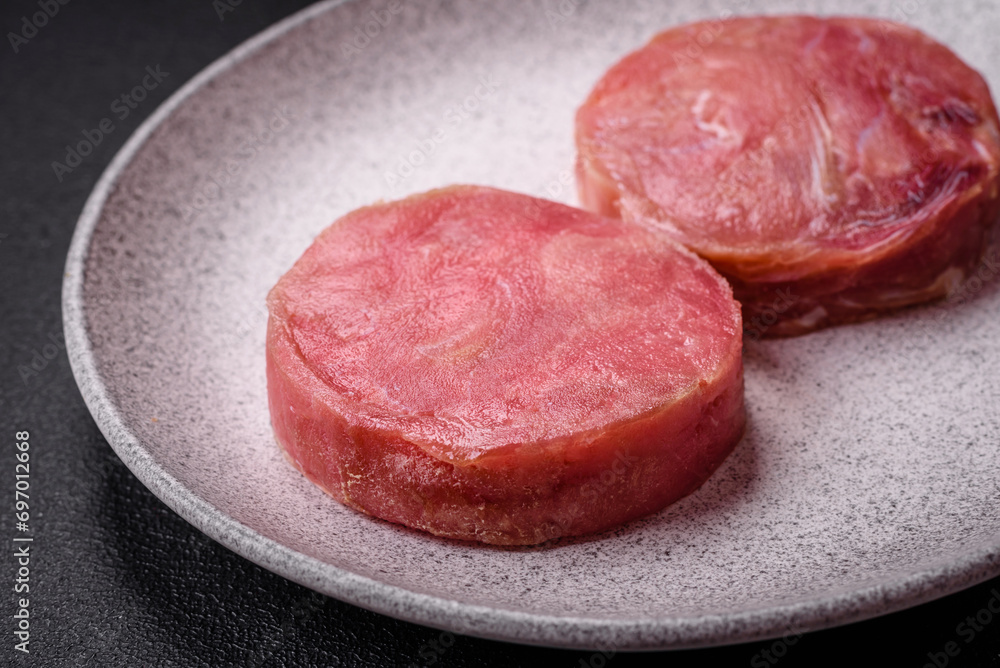 Round shape steaks of raw juicy tuna with salt and spices Round shape steaks of raw juicy tuna with salt and spices