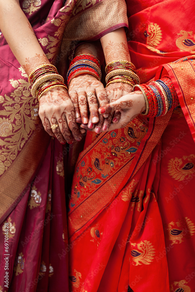 Indian Wedding Ceremony Concept. Two women wearing sarees and displaying their bangles at an Indian wedding ceremony.