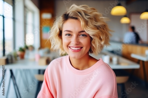 Smiling woman with a short blonde haircut indoors. The concept of casual beauty and happiness.