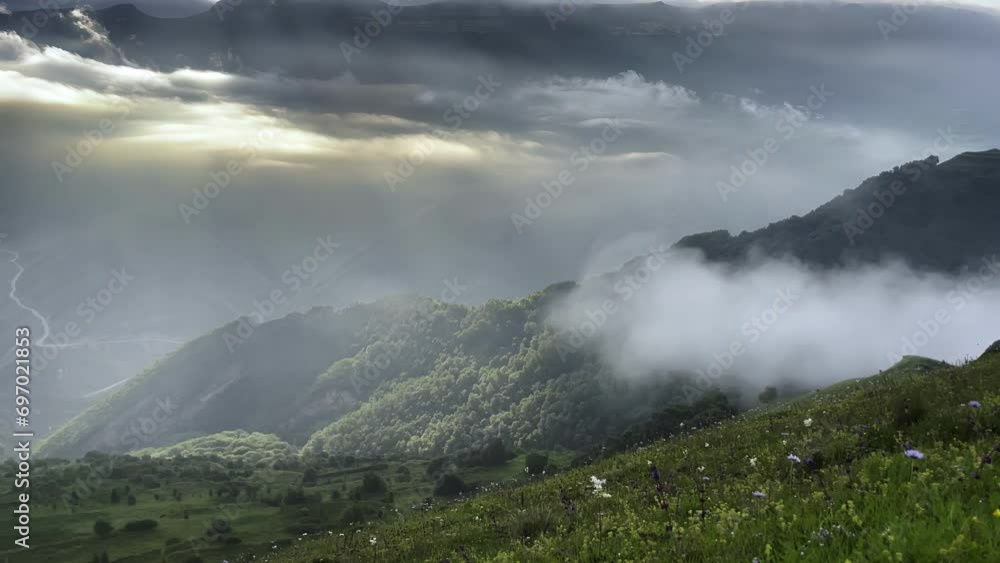 fabulous view in the mountains, clouds below the mountains, the sun's rays seep through the clouds, clouds float under the top of the mountain fabulous view in the mountains, clouds below the mountains, the sun's rays seep through the clouds, clouds float under the top of the mountain