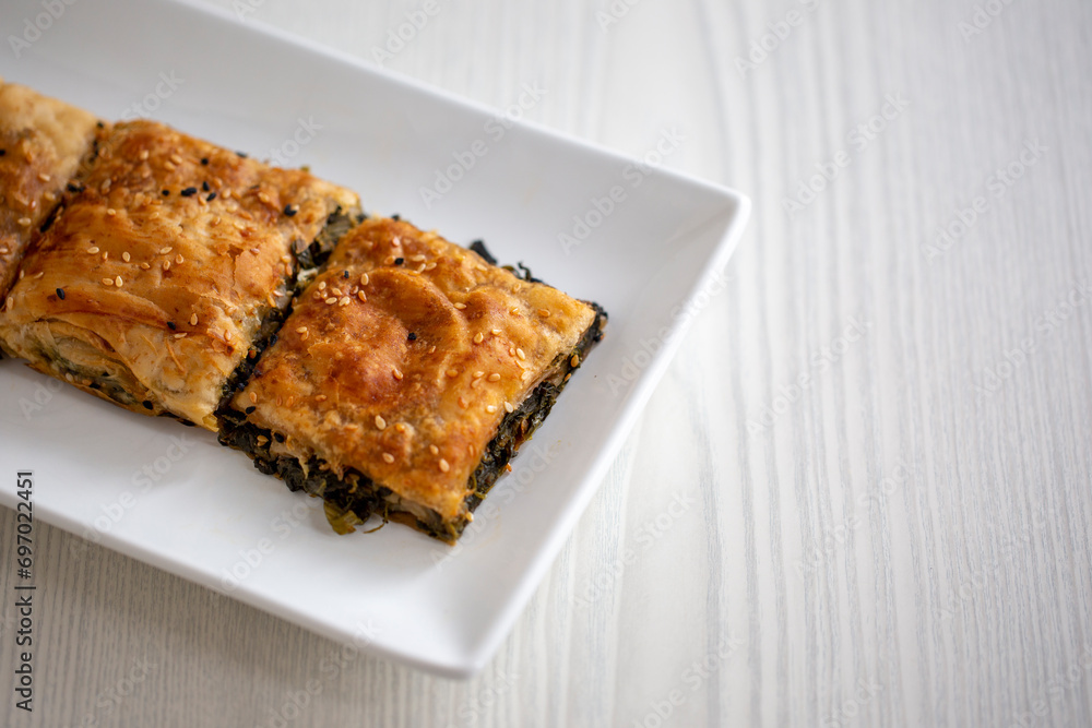 borek with spinach on white wooden table borek with spinach on white wooden table