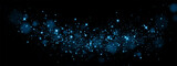 Bokeh, dust sparks and blue stars shine with special light. Vector sparks on black background. Christmas light effect. Sparkling magic dust particles.