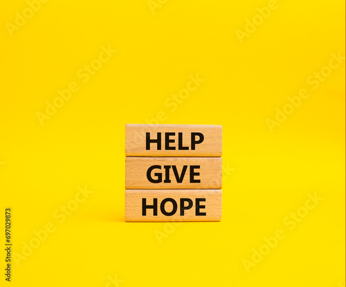Help Give Hope symbol. Concept words Help Give Hope on wooden blocks. Beautiful yellow background. Business and Help Give Hope concept. Copy space.