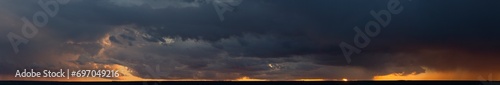 Landscape at sunset. A thunderstorm is approaching the village. Tragic gloomy sky. Panorama.