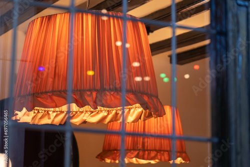 zwei orangefarbene Lampenschirme hinter einem Fenster  photo