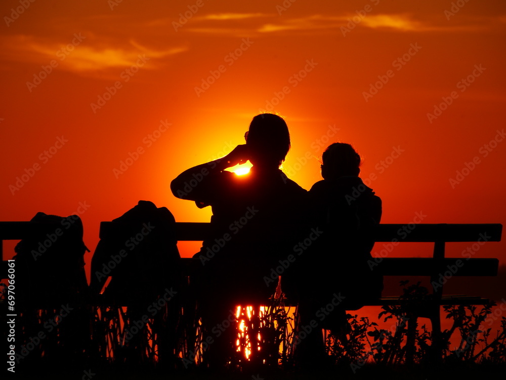 Fototapeta premium couple sitting bench sunset relaxing