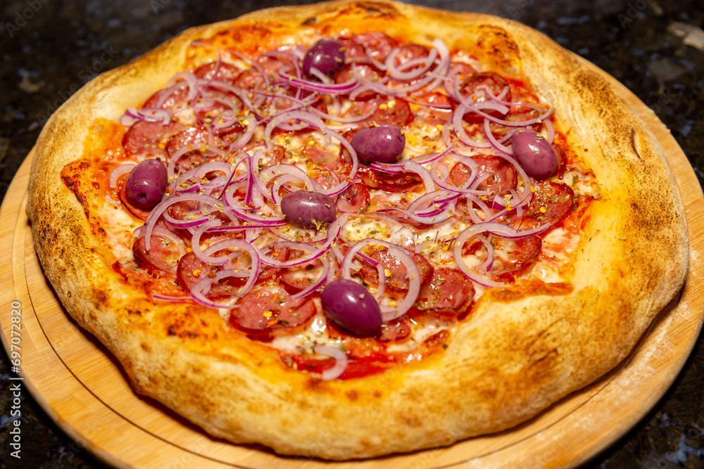 Traditional Calabrian sausage pizza with red onion and black olives