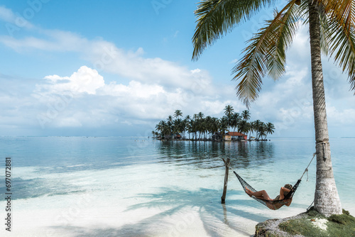 Woman lying on an hammock in an idyllic tropical beach photo