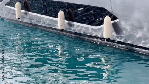 Sun glare on glossy board of mega yacht, anchor, tranquillity in port Hercules, bow of moored huge boat at sunny day, Monaco, Monte-Carlo