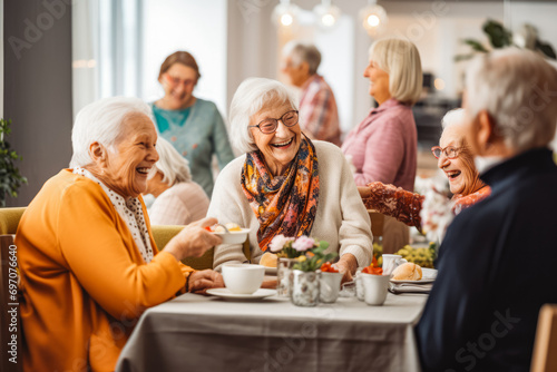 Smiley seniors dancing and having fun celebrating birthday in nursing home, elderly people enjoying a lively social activity gathering photo