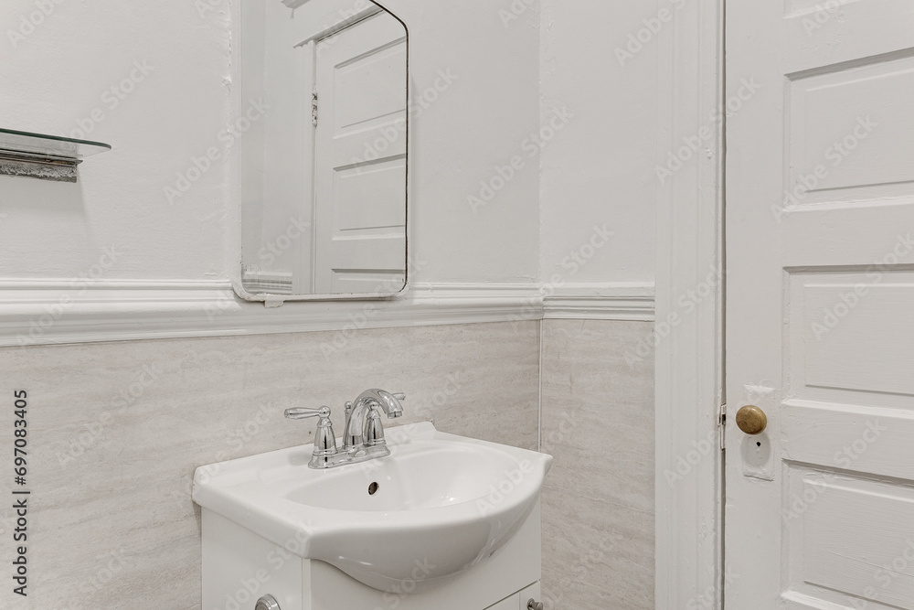 Obraz premium Contemporary Half Bathroom with Sleek White Pedestal Sink, Marble Wall Tiles in Urban Apartment