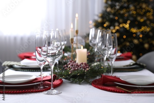 Christmas table setting with festive decor and dishware indoors