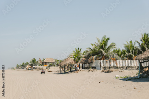 sunny beach in mexico with palm trees and huts photo