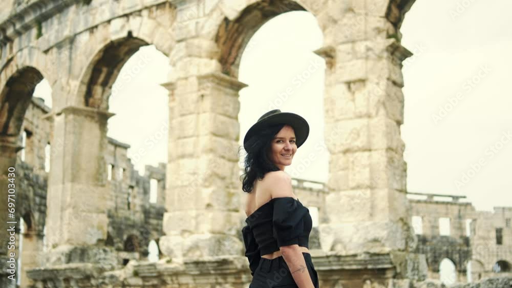 Delighted young executive woman in black classic forma enyoing with great view of Colosseum in Pula. Delighted young executive woman in black classic forma enyoing with great view of Colosseum in Pula.
