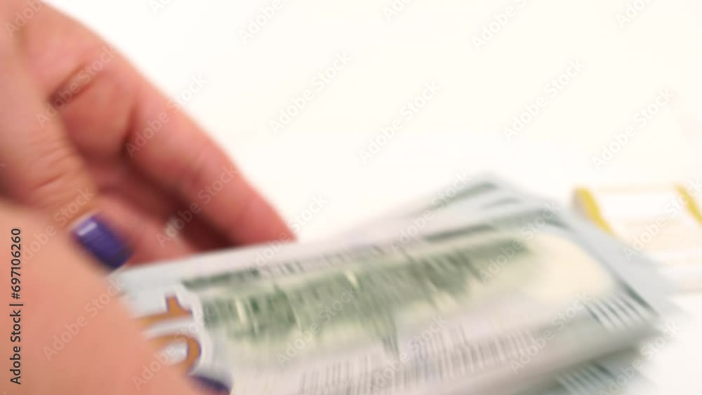 Female hands, dollar counting. Depicting finance and accounting themes. A person is counting 100 dollar bills on a white table. Female hands, dollar counting. Depicting finance and accounting themes. A person is counting 100 dollar bills on a white table.
