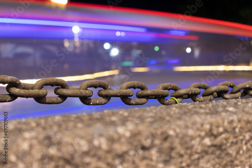 Chain fence with moving lights behind