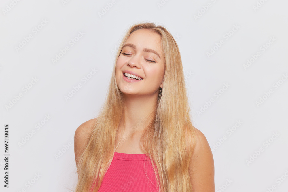 Portrait of pretty girl with long golden hair in pink top over background with closed eyes, beautiful people concept, copy space Portrait of pretty girl with long golden hair in pink top over background with closed eyes, beautiful people concept, copy space
