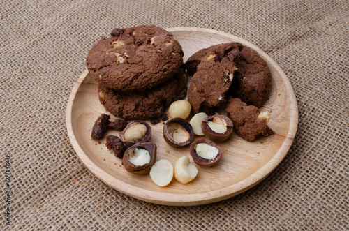Soft Chewy delicious cookies with chocolate chips and macadamia on white wood plate