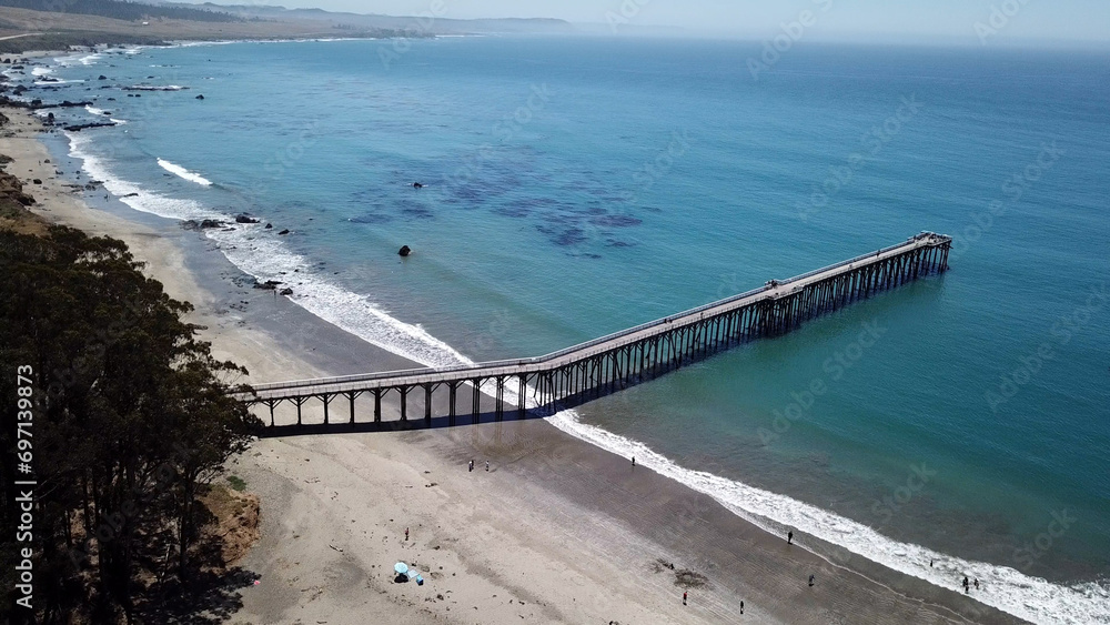 Drone aerial photo of the California coastline with cliffs and rocky beach side coastline in San Simeon pier