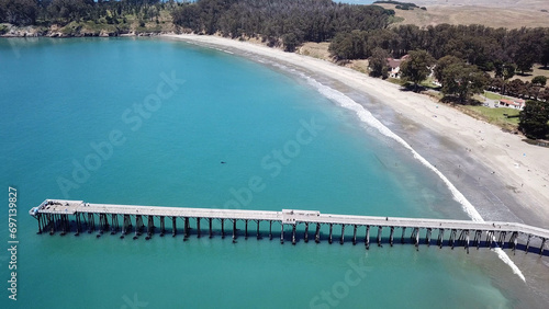 Drone aerial photo of the California coastline with cliffs and rocky beach side coastline in San Simeon pier