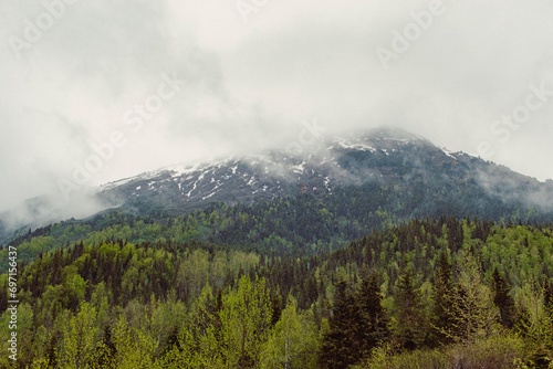 Dramatic fog rolls over a mountain range in Alaska. © Cavan