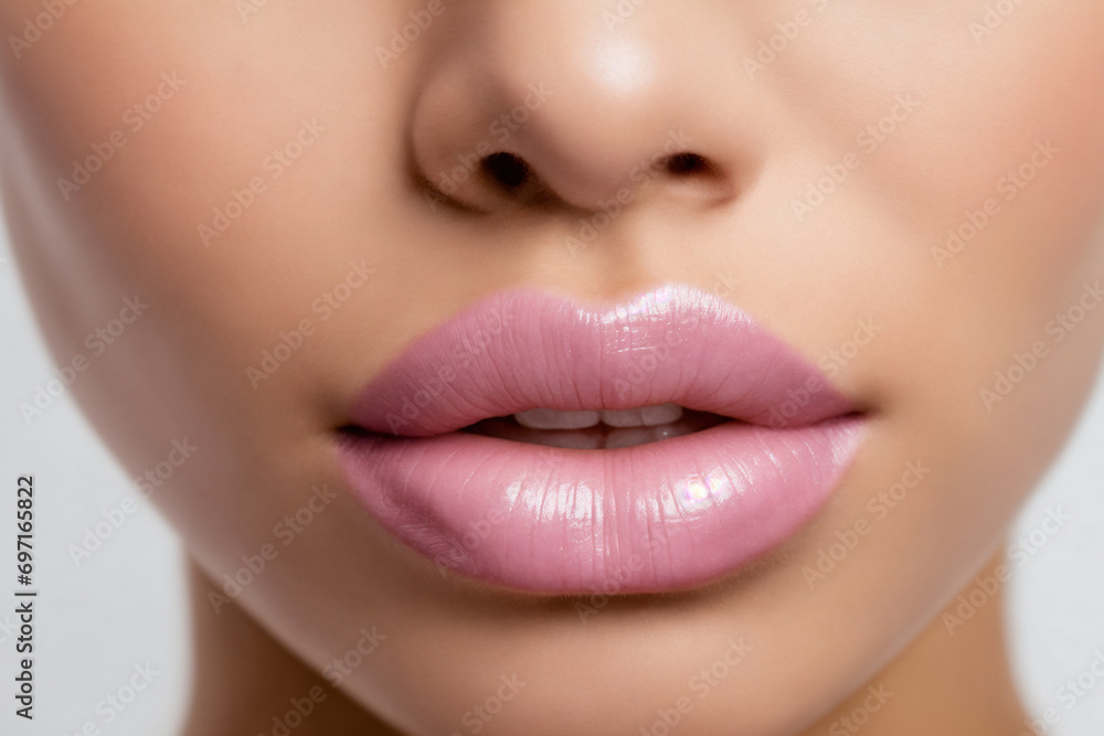Fototapeta premium Close-up of beautiful lips with light pink lipstick