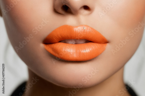 Close-up of beautiful lips with orange lipstick photo