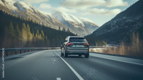 Rear of car driving on highway in the forest with mountain in winter © Fly Frames