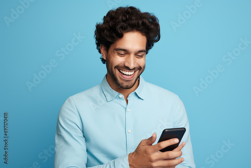 man looking at phone standing isolated on blue background