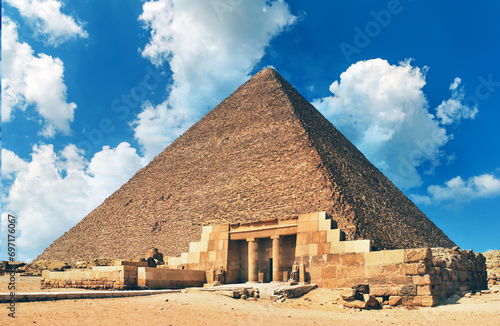 Egyptian Great Sphinx full body portrait with head, feet with all pyramids of Menkaure, Khafre, Khufu in background on a clear, blue sky day in Giza, Egypt empty with nobody. copy space
