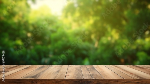 Table top made of empty wood with a blurred abstract green background from a house and garden. For product showcase montage © juni studio