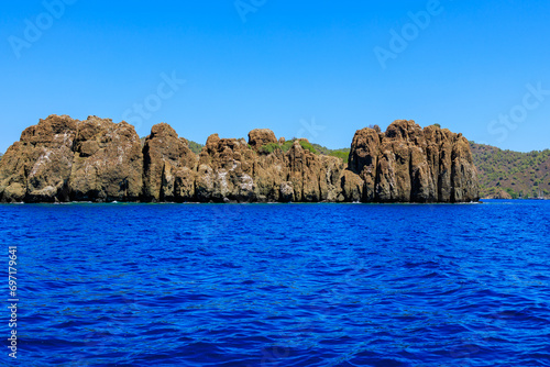 Rocky coast in the resort part of the Mediterranean or Aegean Sea. Background with selective focus and copy space