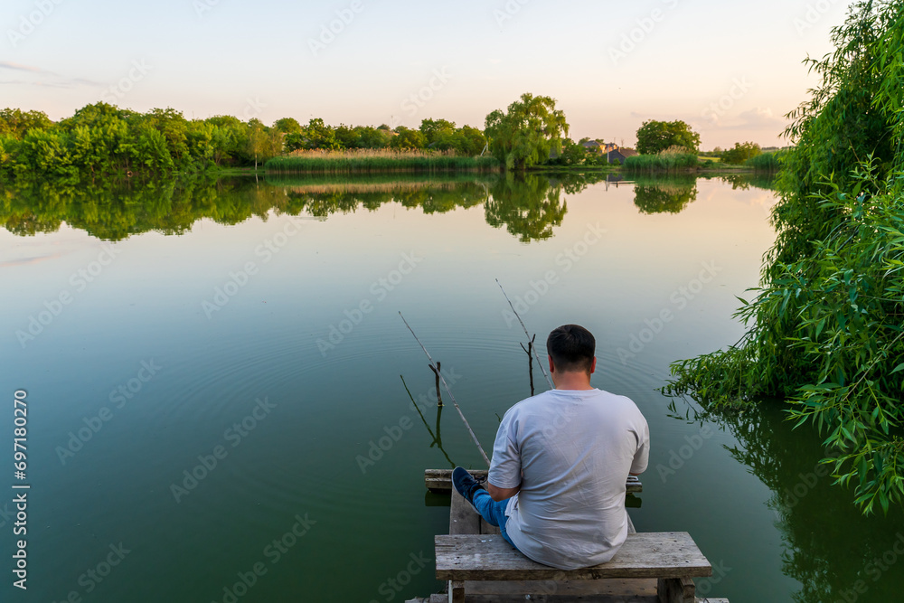 The fisherman sits waiting for a bite. Background with selective focus and copy space The fisherman sits waiting for a bite. Background with selective focus and copy space