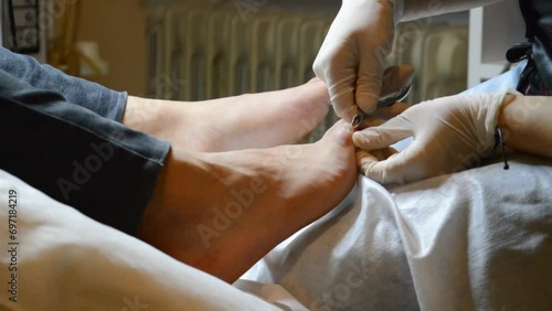 Girl in Beauty Salon doing pedicure to her male patient's toes photo