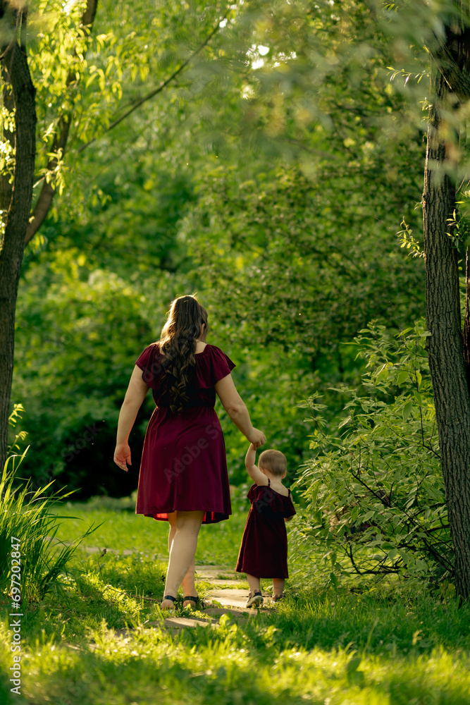 Forward they walk, through the dappled light of a vibrant green path, a journey of togetherness and the quiet strength of maternal guidance. Forward they walk, through the dappled light of a vibrant green path, a journey of togetherness and the quiet strength of maternal guidance.