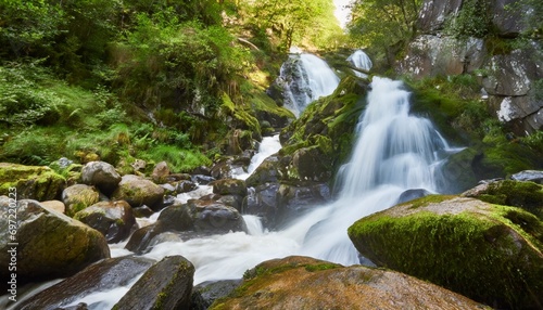 waterfall in a green forest with rocks and green moss