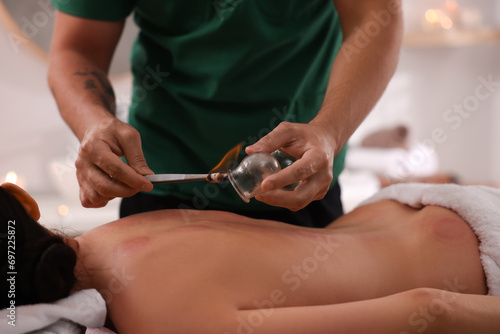 Therapist giving fire cupping treatment to patient indoors  closeup
