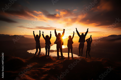 hikers celebrating success on top of a hill in the sunset photo