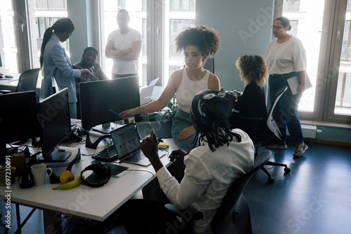 Multiracial male and female entrepreneurs working together at coworking office photo
