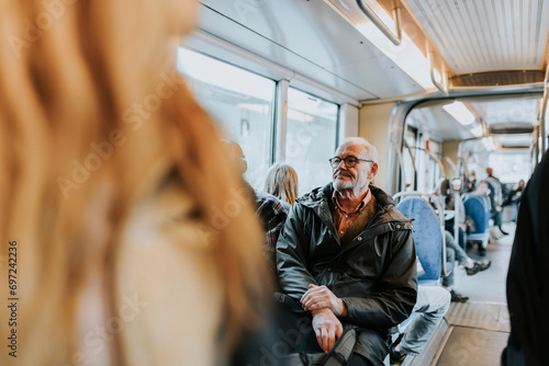 Contemplative male owner sitting in bus while traveling to work photo