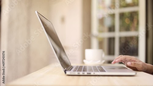 A woman's hand closes a laptop and slowly closes it. Turn off the laptop screen when work is complete.

