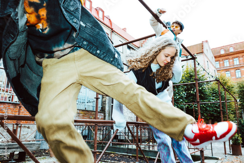 Multiracial male and female friends jumping over railing against building photo