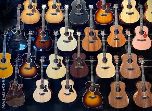 a wall full of acoustic guitars of different models and types of wood, guitars store, guitars hanging in a wall,  horizontal