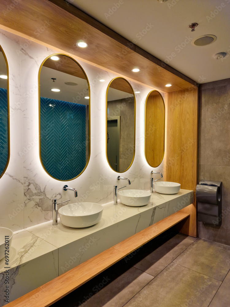 Contemporary interior of public toilet with sinks and mirrors Contemporary interior of public toilet with sinks and mirrors