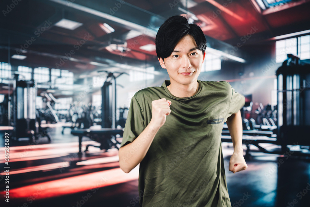 Fototapeta premium スポーツジムでランニングをする若い男性